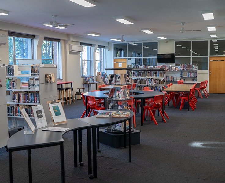 Image of our school library with books, and areas for students to study.