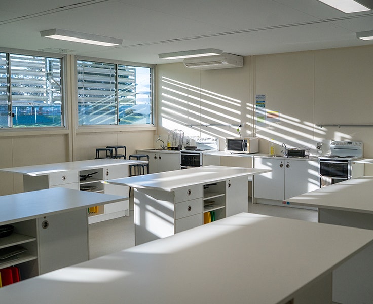 An image of our third demountable kitchen with ovens, stove tops and workbenches in a white finish.
