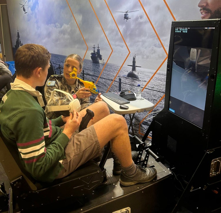 An image of one of our students at the Western Sydney Careers Expo as they participate in a flight simulator demonstration by the Australian Defence Force at their booth.